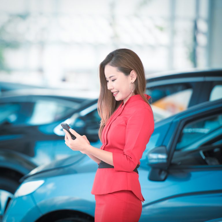 Woman using cell phone to speak to prospective customer in the showroom
